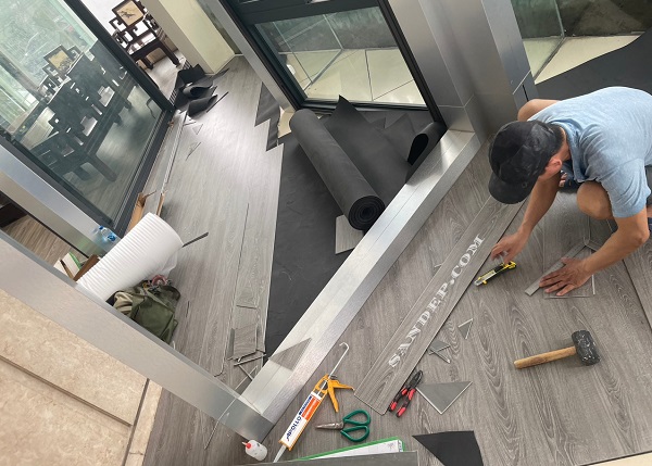 Thợ lát sàn nhựa giả gỗ Ecoclick 474 trên foam xốp lót cao su đen.